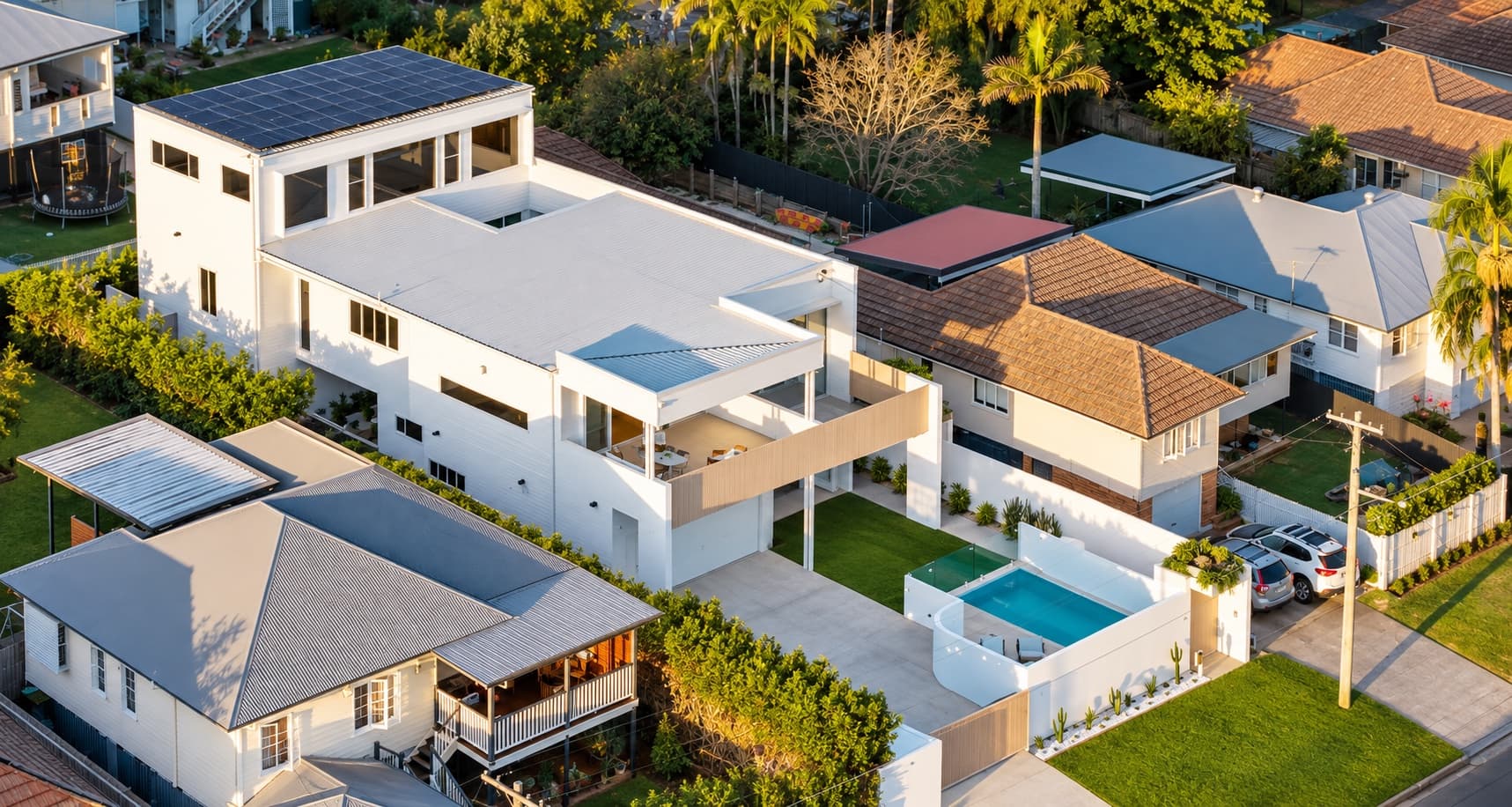 two-storey home with a mono-pitched roof, exposed timber eaves, and stacked-stone entry feature — SNG Engineers