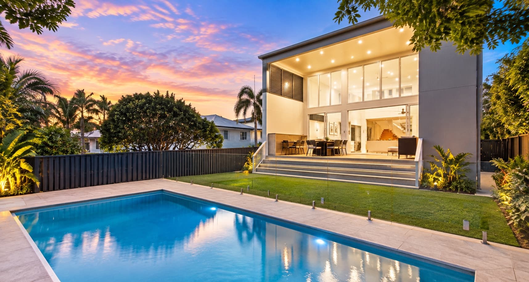 rear elevation of an architectural home showing tiered outdoor living decks stepping down a sloping site — SNG Engineers