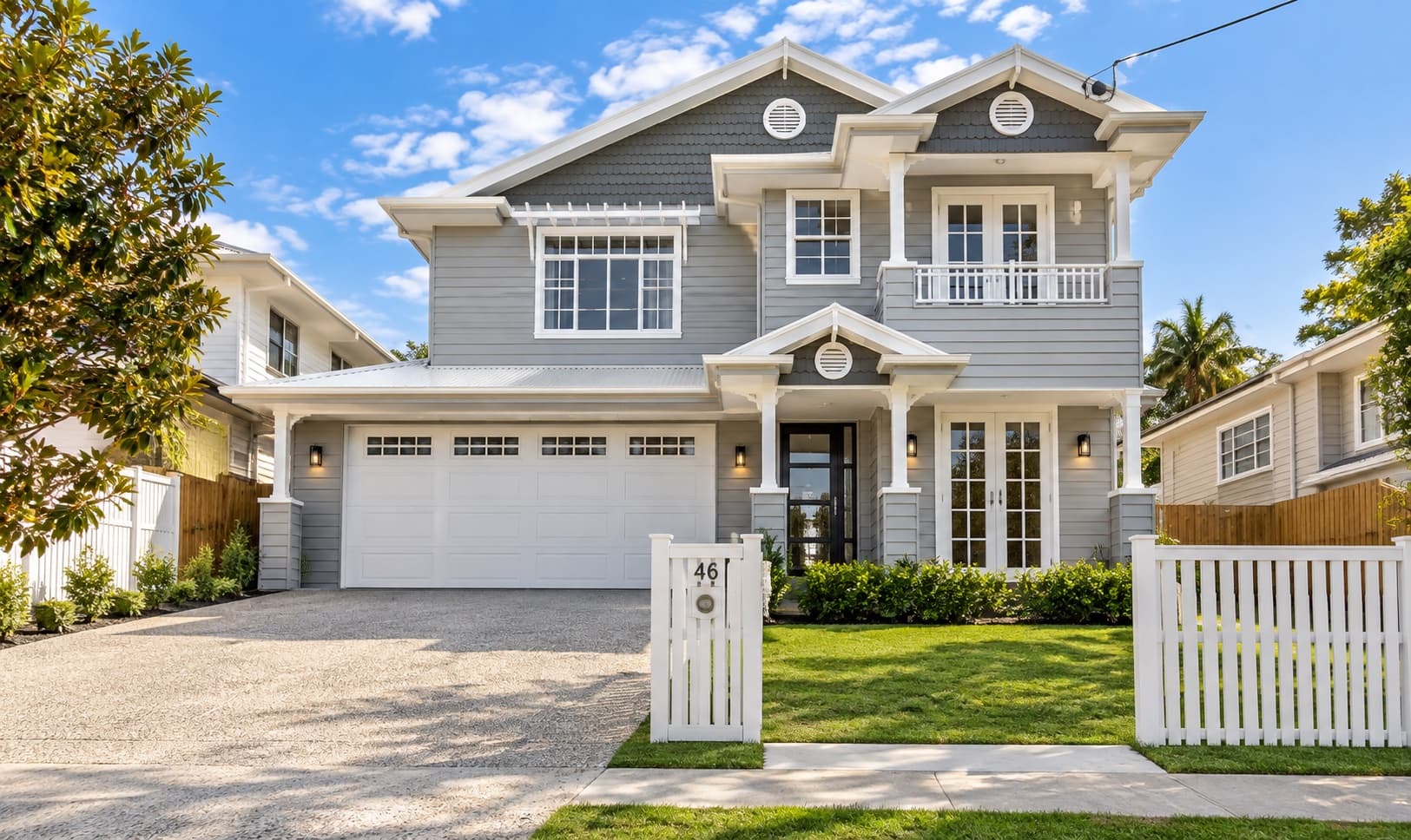 two-storey Hamptons-style project home with grey shiplap cladding and gabled entry portico — SNG Engineers