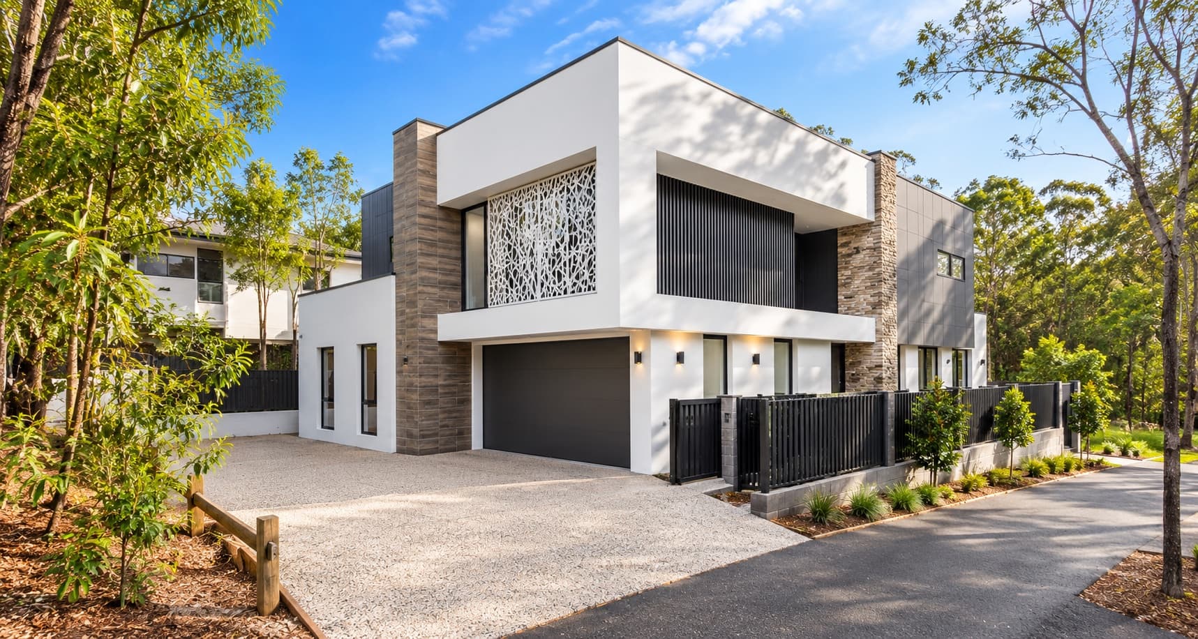 contemporary two-storey project home with stone and timber cladding set among established trees — SNG Engineers