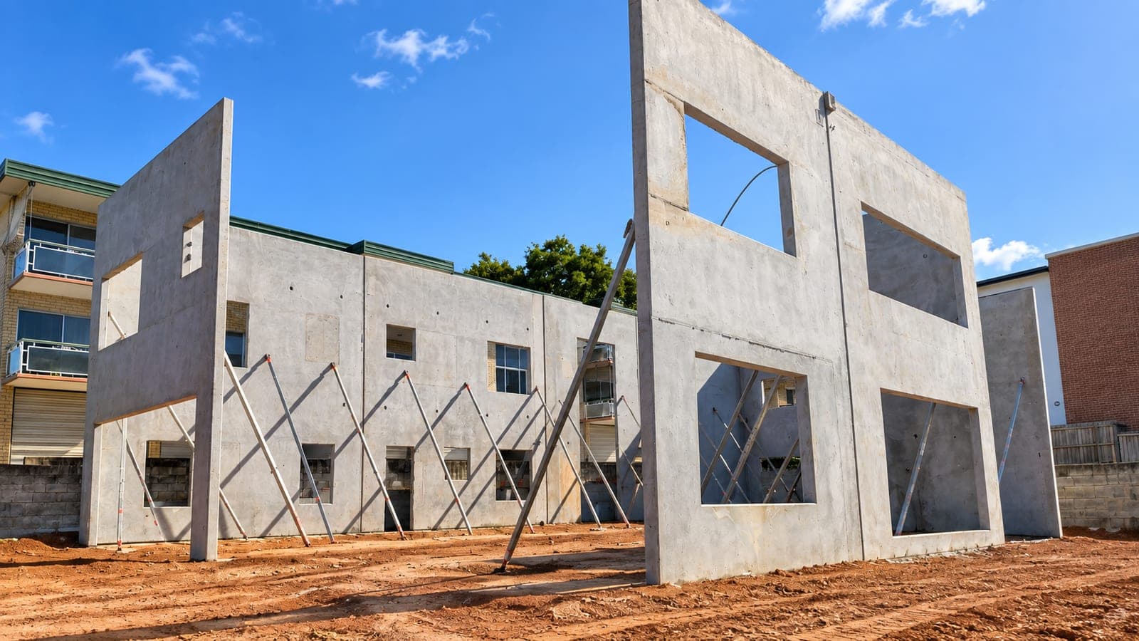 Tilt-up concrete panels braced upright on a multi-unit residential slab